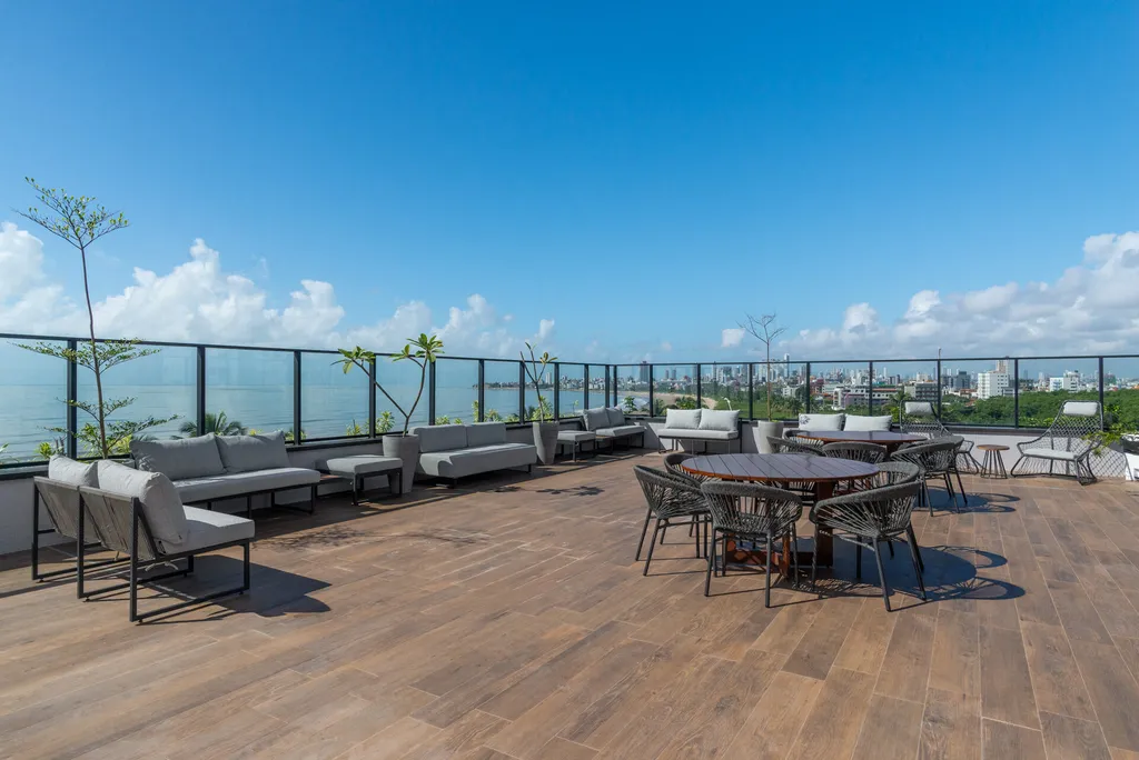 Área de mesas do rooftop do Urban Blue View com vista para o mar